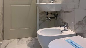 A bathroom with a toilet, sink, and mirror. - Hotel Marittima (Rimini)
