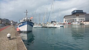 A marina with several boats docked, a building labeled "Hôtels de France," and a cobblestone walkway. - Appartement Belle vue Centre Ville Fécamp 1 km de la Plage (Fécamp)
