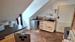 A modern kitchen with a herringbone wood floor, a dishwasher, a coffee machine, and a built-in oven. - Appartement Belle vue Centre Ville Fécamp 1 km de la Plage (Fécamp)