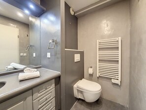 A modern bathroom with a grey sink, a mirror, a toilet, and a towel rack. - N&J - CITY HEART - Close Place Masséna (Niza)