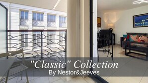 Un balcon avec une balustrade en métal, une chaise et une table.