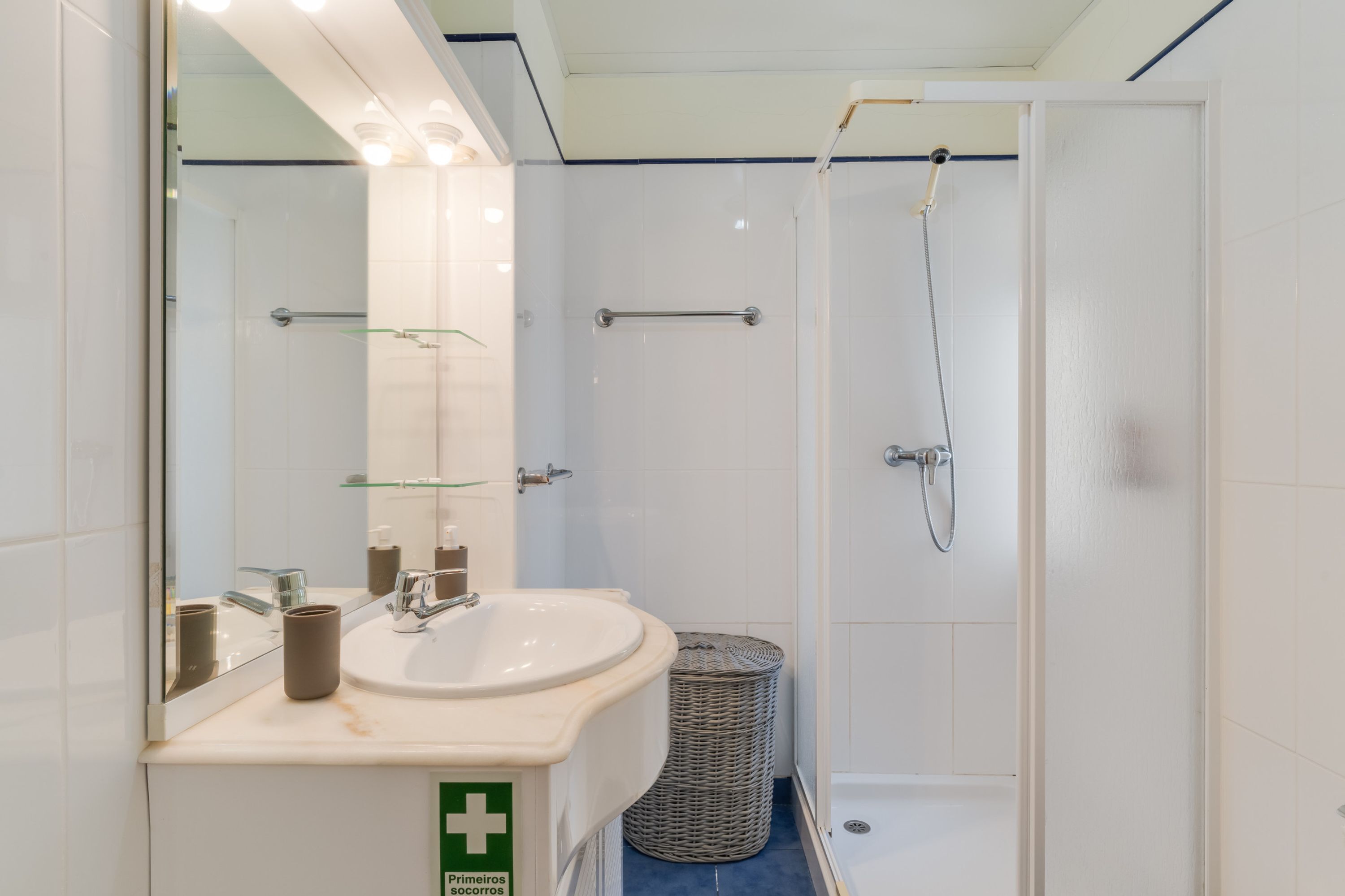 Une salle de bain moderne avec un lavabo, un miroir et une douche.