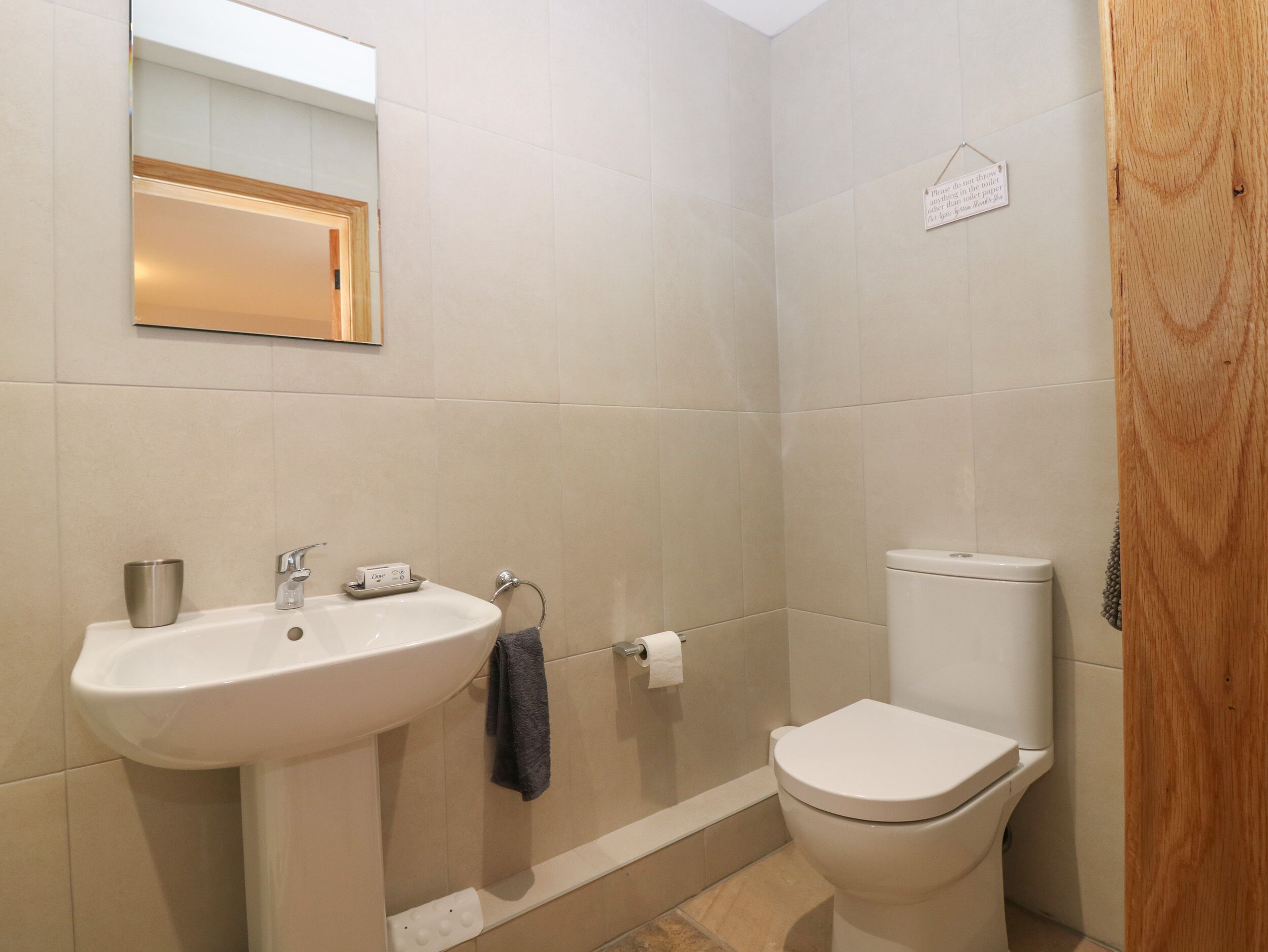Une salle de bain avec un lavabo, un miroir, des toilettes et une serviette accrochée au mur.