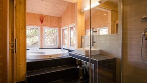 A modern bathroom with a glass shower enclosure, a freestanding bathtub, and a vanity with a sink.