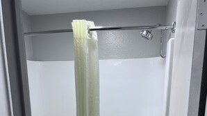 Un baño con bañera, inodoro y cortina de ducha.