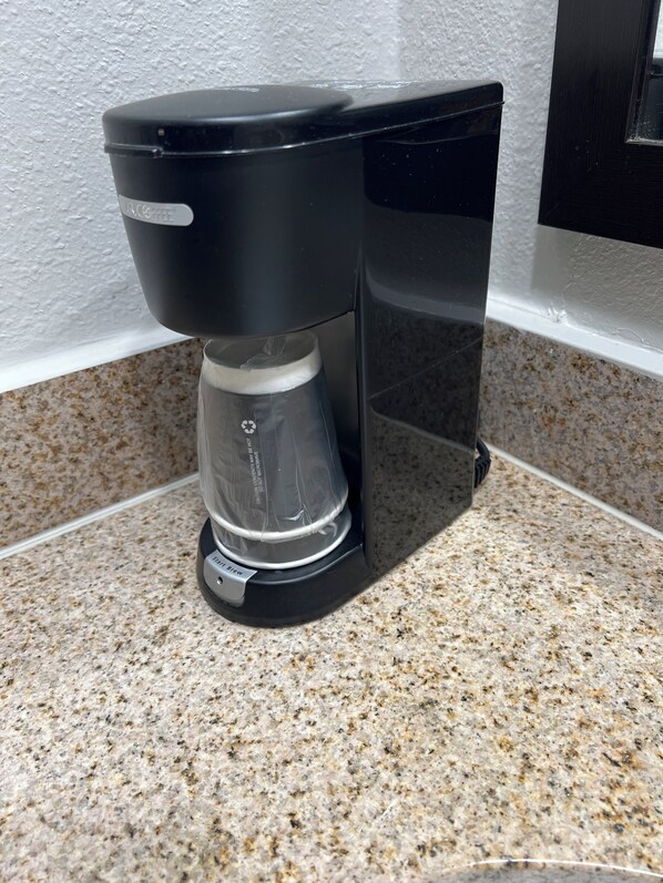 A coffee maker on a granite countertop.