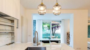A modern kitchen with a central island, stainless steel appliances, and pendant lighting. - Luxury House by Interhome (Colico)