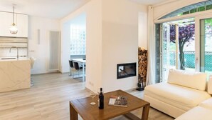 A modern living room with a wooden coffee table, a sofa, and a dining area with a table and chairs. - Luxury House by Interhome (Colico)