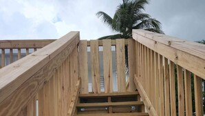 A wooden staircase with a palm tree in the background. - Scenic Views in Paradise Resorts (Canovanas)