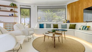 Ein modernes Wohnzimmer mit einem weißen Sofa, einem runden Couchtisch und eingebauten Regalen.