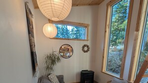 Una sala de estar acogedora con sofá, una mesa de centro y chimenea. Hay un ventanal que ofrece vistas al exterior.