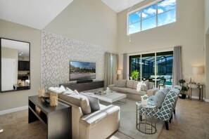Relax in this stylish living room with a large flat-screen TV, comfortable seating area, and dining space.