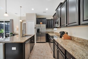 Enjoy cooking in this well-equipped kitchen with a stainless steel refrigerator, sink, and dishwasher.