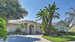 A two-story house with a front porch, a garage, and a well-maintained lawn. - Private pool home with hot tub and games room - premium gated community (Kissimmee)
