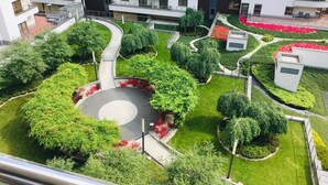 Een wooncomplex met meerdere flatgebouwen, een centrale ronde tuin en omliggend groen.