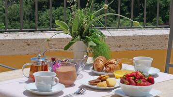 A table set with breakfast items, including croissants, strawberries, and a coffee pot.