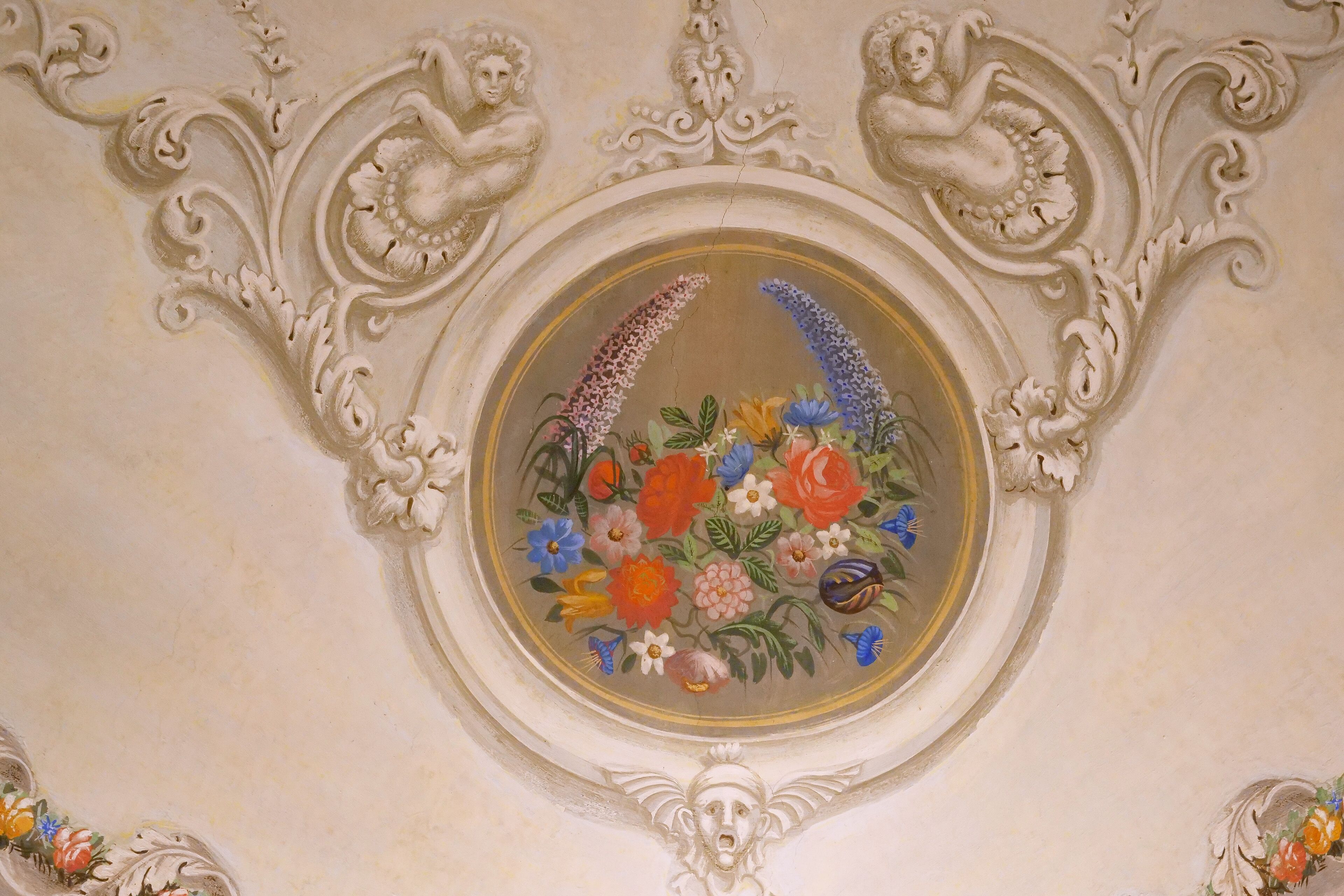 Techo con un diseño floral circular rodeado de adornos ornamentales.