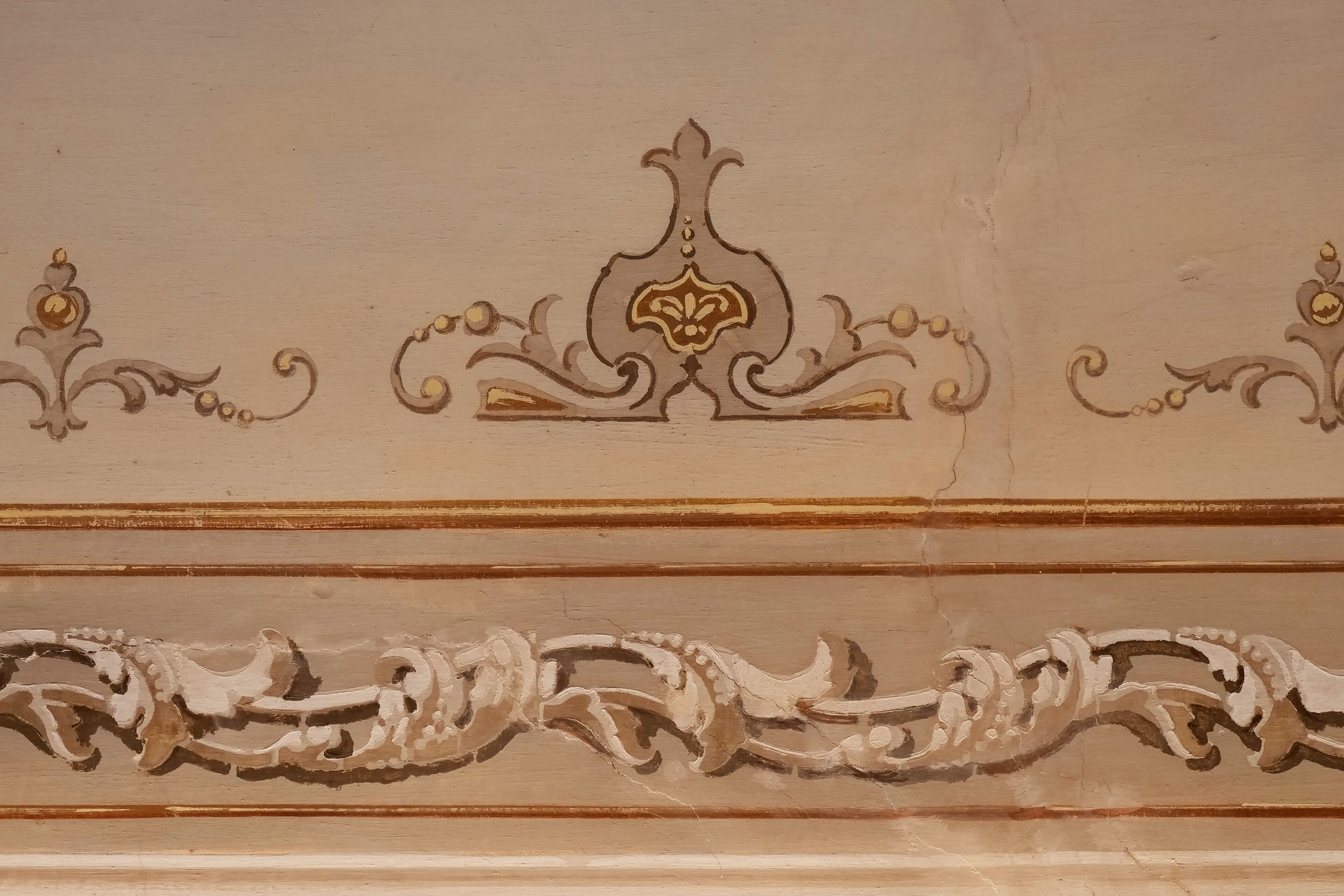 A ceiling with ornate, symmetrical moldings and a central decorative element.