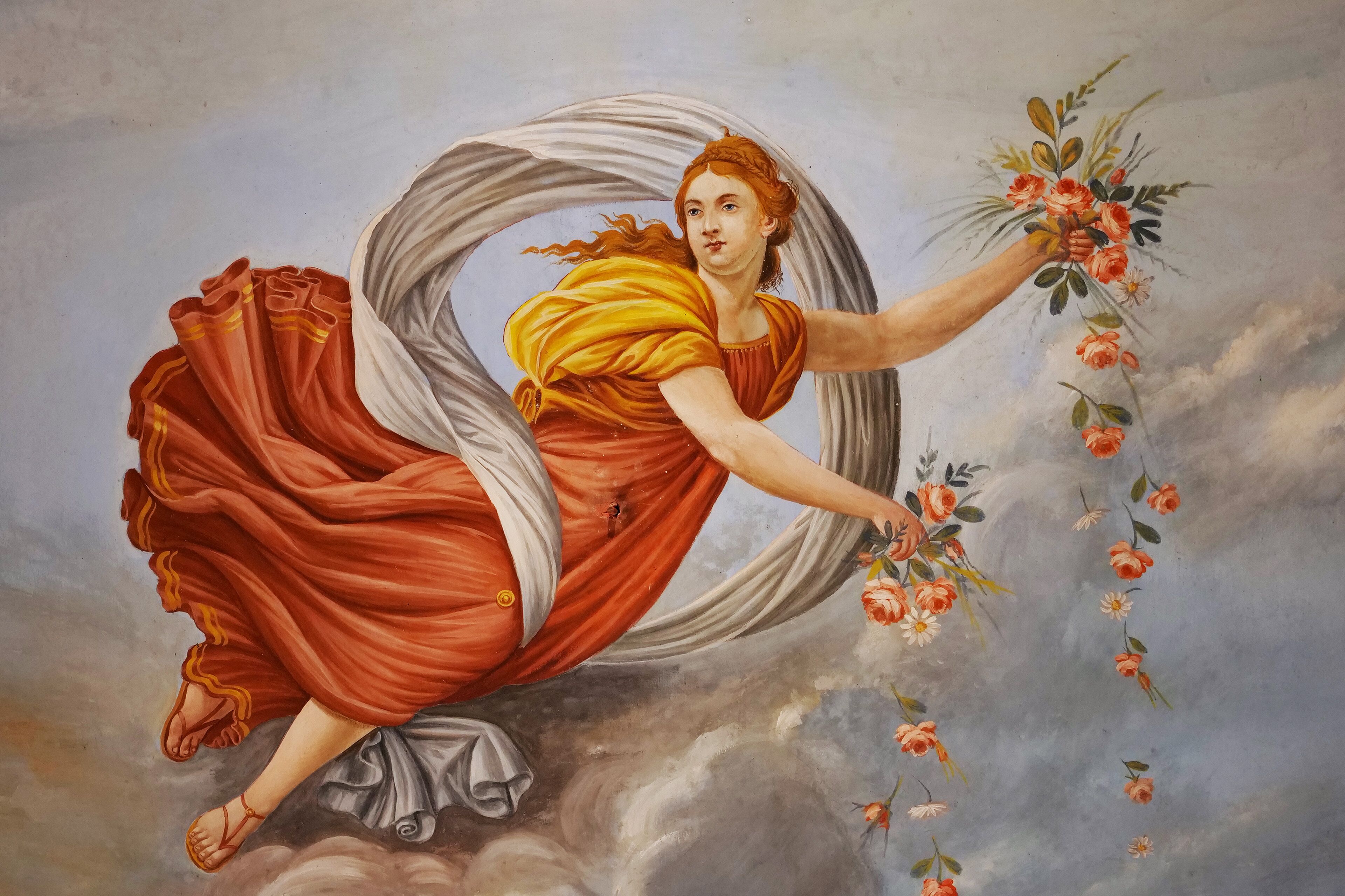 Een klassiek schilderij van een vrouw in een zwierige rode jurk, met een boeket bloemen, voor een bewolkte lucht.