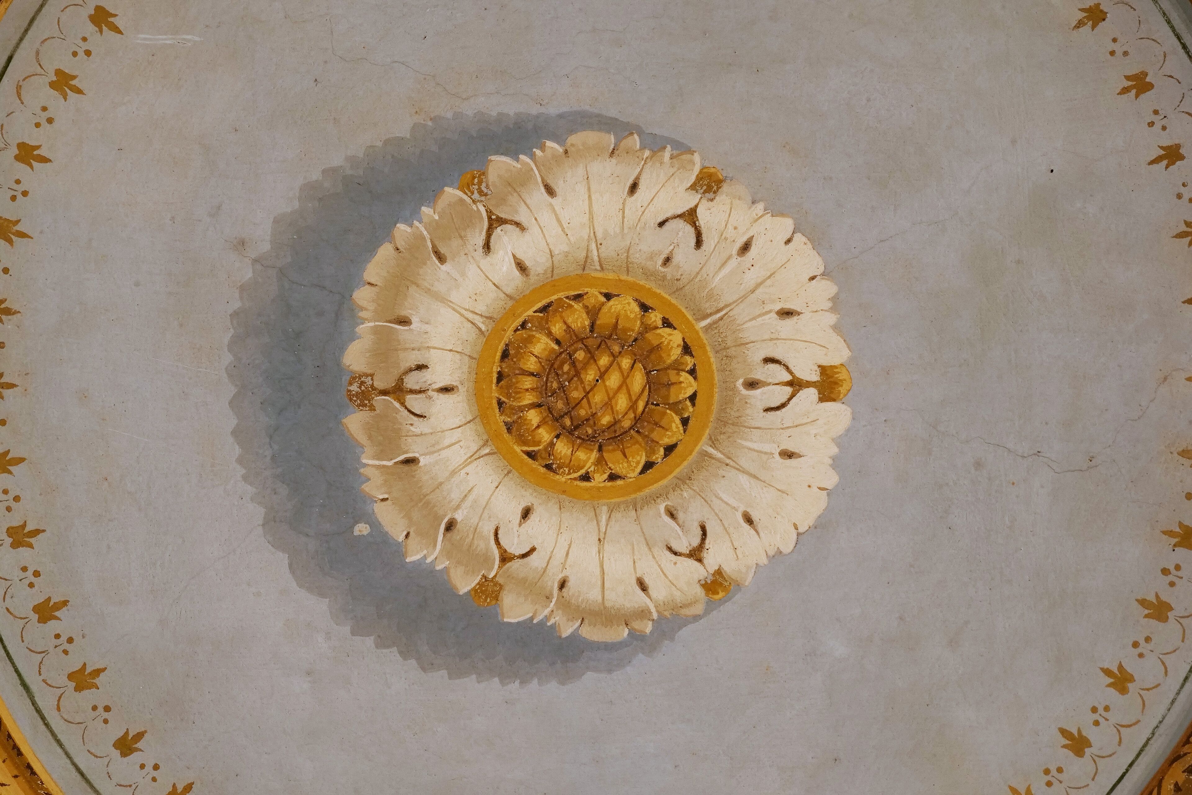 Teto com um desenho floral circular.