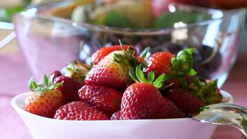 A bowl of fresh strawberries with a spoon.