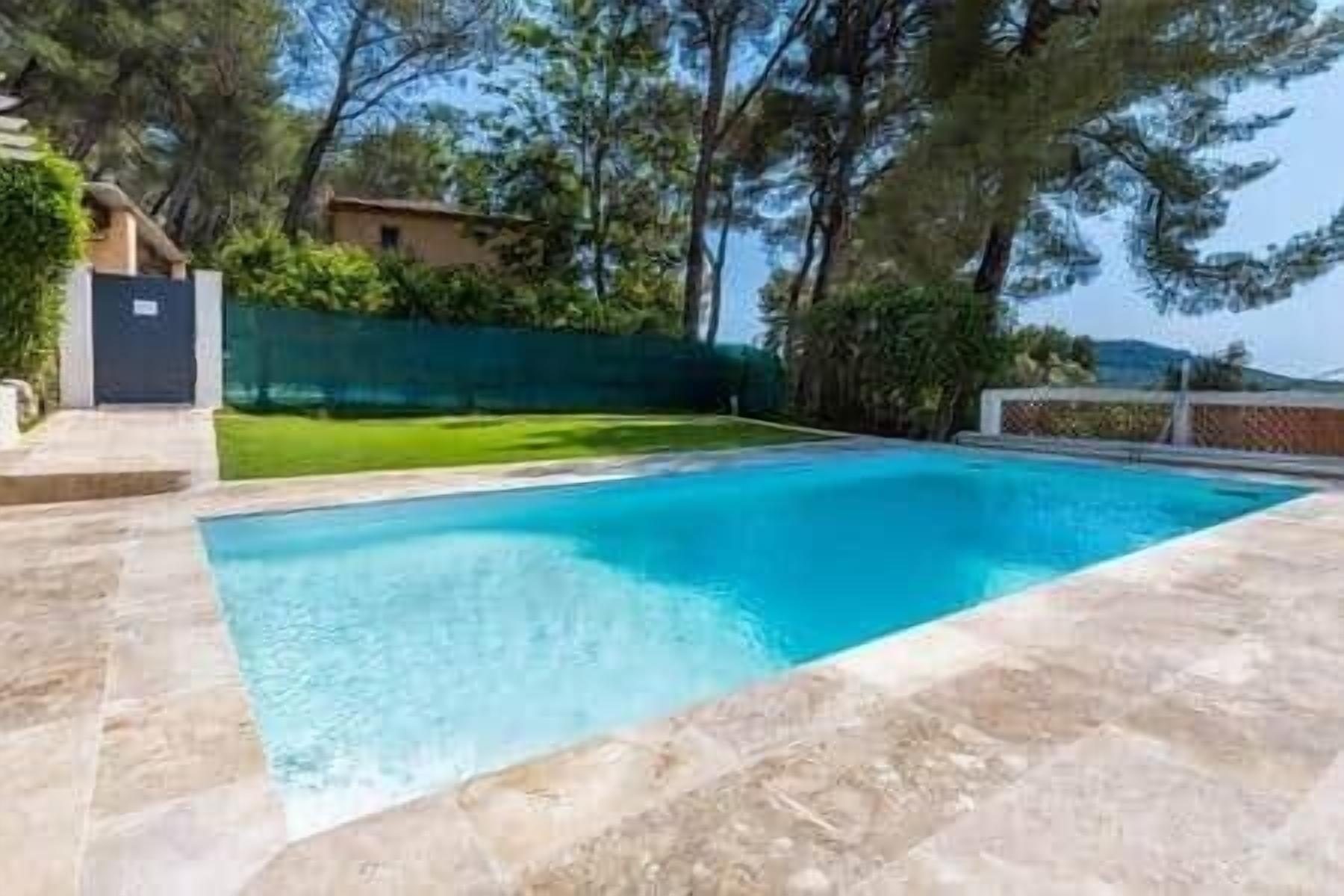 A rectangular swimming pool with a clear blue water surface, surrounded by a stone deck.