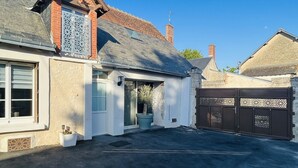 A residential property with a garage, a large potted plant, and a decorative gate.