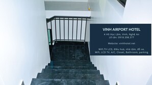 Una escalera que lleva a una habitación de hotel, con un cartel que muestra el nombre y los servicios del hotel.