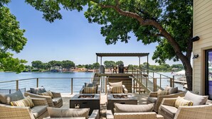 A patio with wicker furniture and a view of a lake. - Luxury LAKEFRONT home  Insane view POPULAR spot 
Sleeps 16+ SERENITY (Kingsland)
