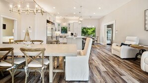 A modern kitchen with white cabinets, a central island, and pendant lighting. - Luxury LAKEFRONT home  Insane view POPULAR spot 
Sleeps 16+ SERENITY (Kingsland)