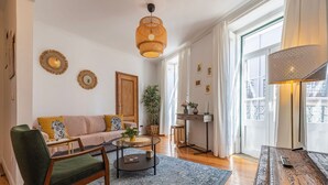 Ein gemütliches Wohnzimmer mit Sofa, einem Sessel, einem Couchtisch und einer dekorativen Lampe.