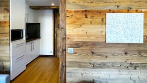 Eine moderne Küche mit weißen Schränken und einer Wand in Holzoptik.