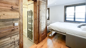 Ein Schlafzimmer mit einem Holzkasten, einem Bett und einem Fenster mit Blick.