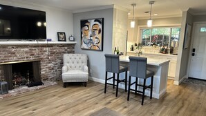 A living room with a fireplace, a television, and a bar area. - Secluded Home w/pool located 5 mins from American River  (Carmichael)