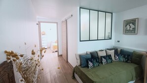 A bedroom with a bed, a dresser, a mirror, and a window.