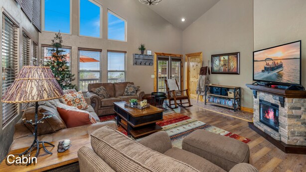 A spacious living room with a fireplace, large windows, and a cozy seating area.