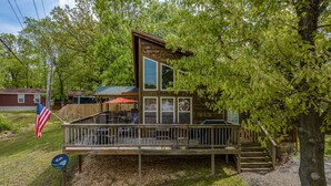 A cabin with a deck, a covered patio, and a satellite dish.