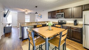 Una cocina moderna con armarios de madera oscura, electrodomésticos de acero inoxidable y una isla central con espacio para sentarse.