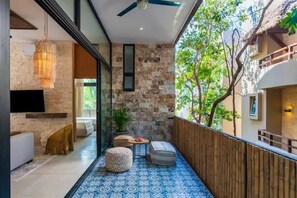 A modern interior with a stone wall, a ceiling fan, and a patterned floor. - Viscount III Manor Tulum By Sandy Powerful (Tulum)
