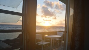 A balcony with a view of the sunset over the ocean, white chairs, and a small table. - Due to repeat guests booking directly with me, I have limited platform reviews. (Christiansted)