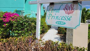 A sign for 'Coral Princessse' with the number 4130, surrounded by lush greenery and a pathway. - Due to repeat guests booking directly with me, I have limited platform reviews. (Christiansted)