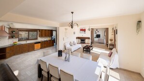 A spacious living area with a dining table, sofas, and a fireplace. - Villa Louna, Letymbou -  a private villa that sleeps 8 guests in 4 bedrooms (Letymbou)