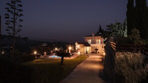 A well-lit pathway leading to a house with a pool, surrounded by greenery and a stone wall. - Villa Louna, Letymbou -  a private villa that sleeps 8 guests in 4 bedrooms (Letymbou)