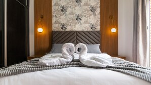A hotel room with a large bed, two wall-mounted lights, a patterned wallpaper, and a wooden headboard. - Great Apartment Marrakesh Gueliz (Marrakesh)