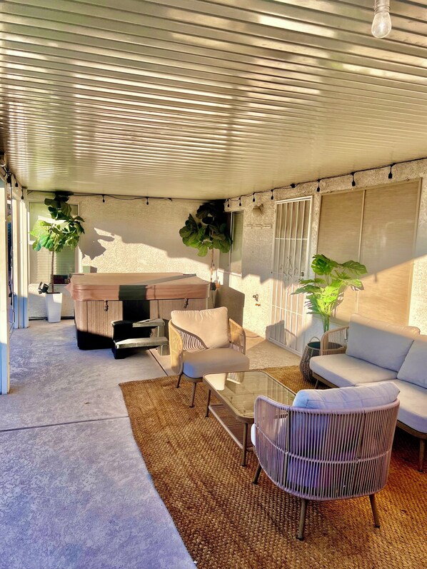Relax in a stylish outdoor seating area with a cushioned sofa, wicker chair, and glass coffee table.