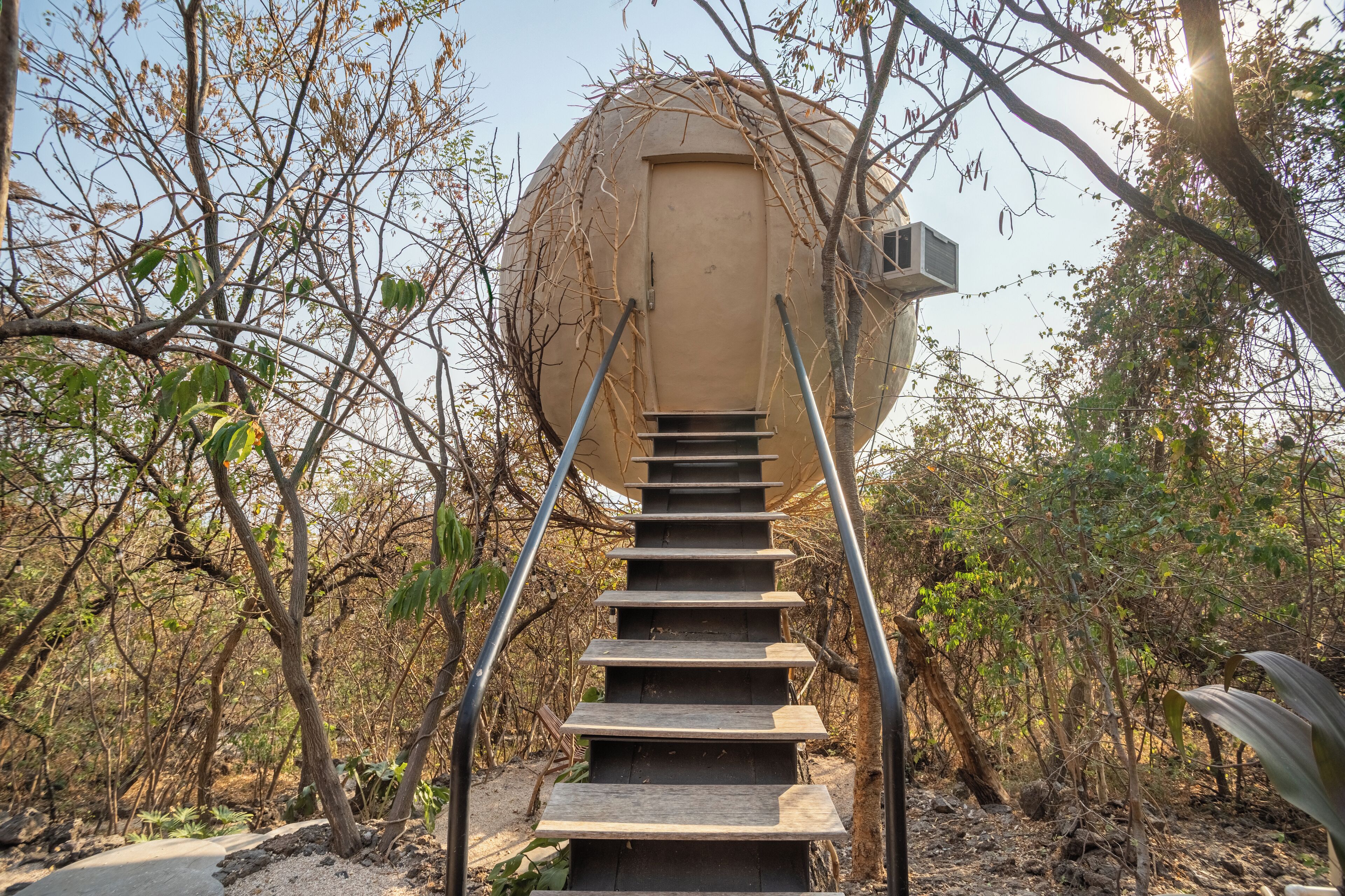 A staircase leading to a spherical structure surrounded by trees.