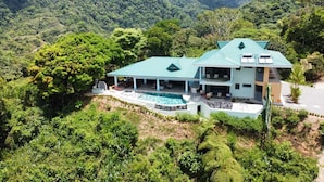 A modern house with a swimming pool, surrounded by lush greenery and hills. - Casa Mono Alegre (Tres Rios)