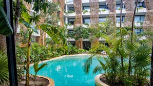 A pool surrounded by lush greenery and modern architecture. - Dk Jade 30 By Sandy Powerful (Tulum)