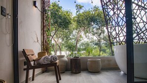 A balcony with a wooden chair, rolled towels, and large planters. - Dk Jade 30 By Sandy Powerful (Tulum)