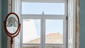 A double door with a white frame and a balcony with a metal railing. - T2 Flores (Porto)